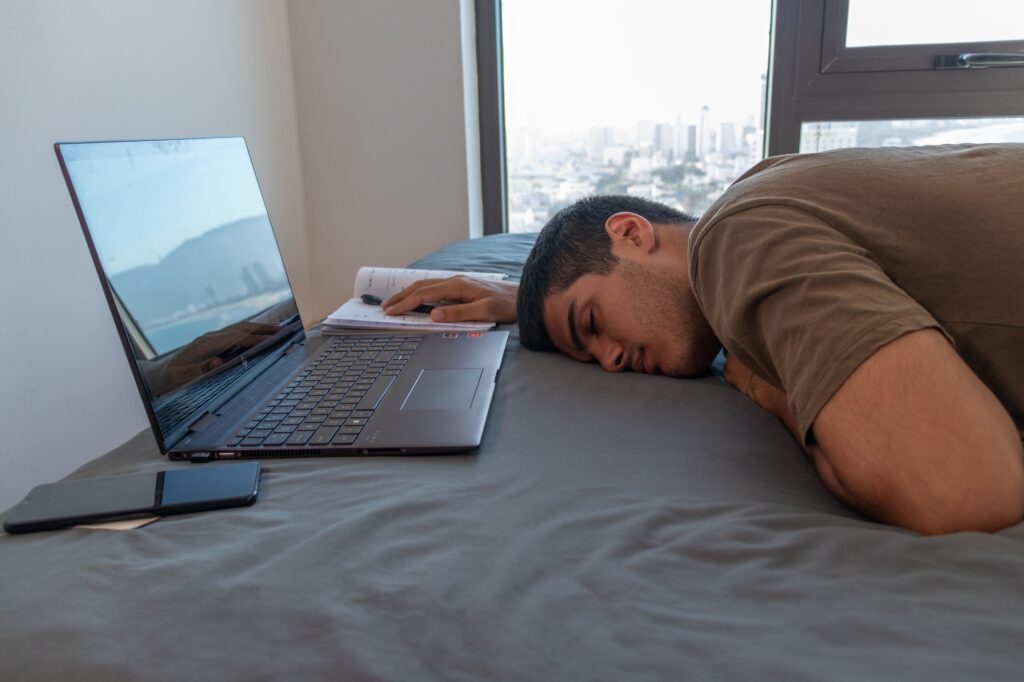 Closeup shot of a young Caucasian procrastinating - study at home concept