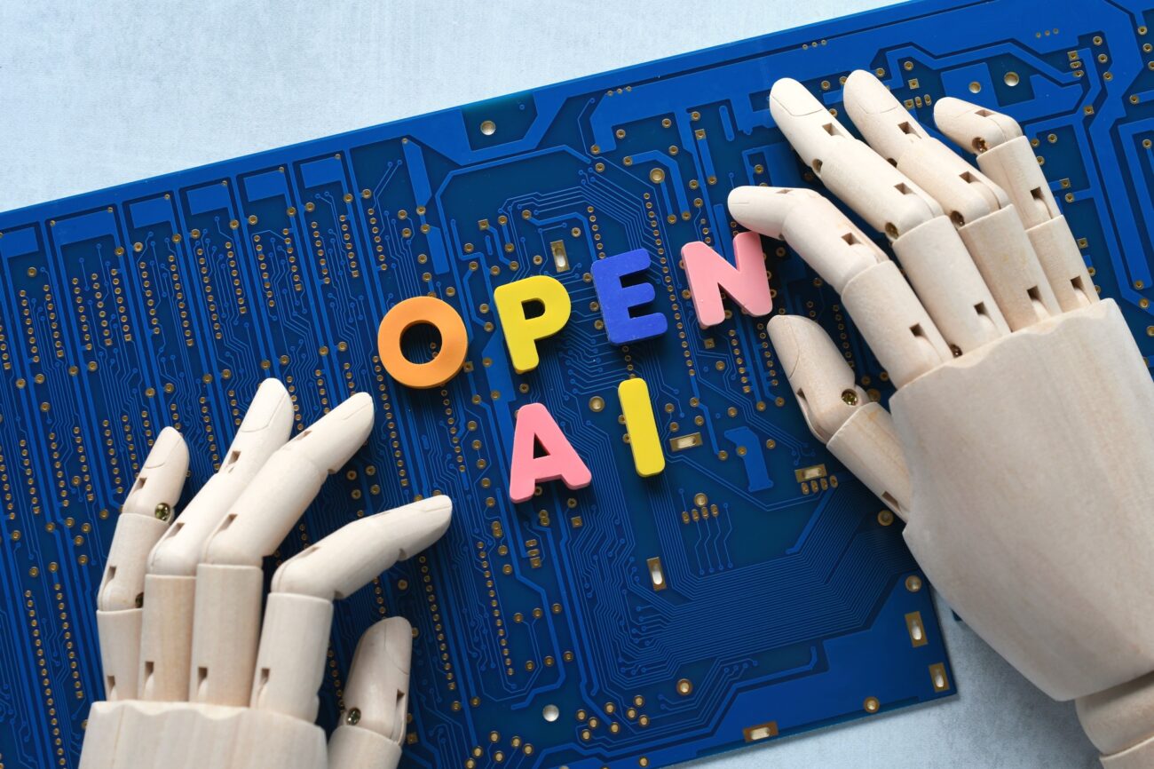 AI artificial intelligence concept - robot hand spelling out Open AI on blue computer motherboard