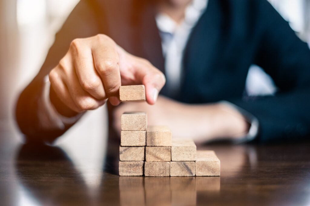 plan and strategy in business.risk concept.hand of man has piling up and stacking a wooden block.Bus